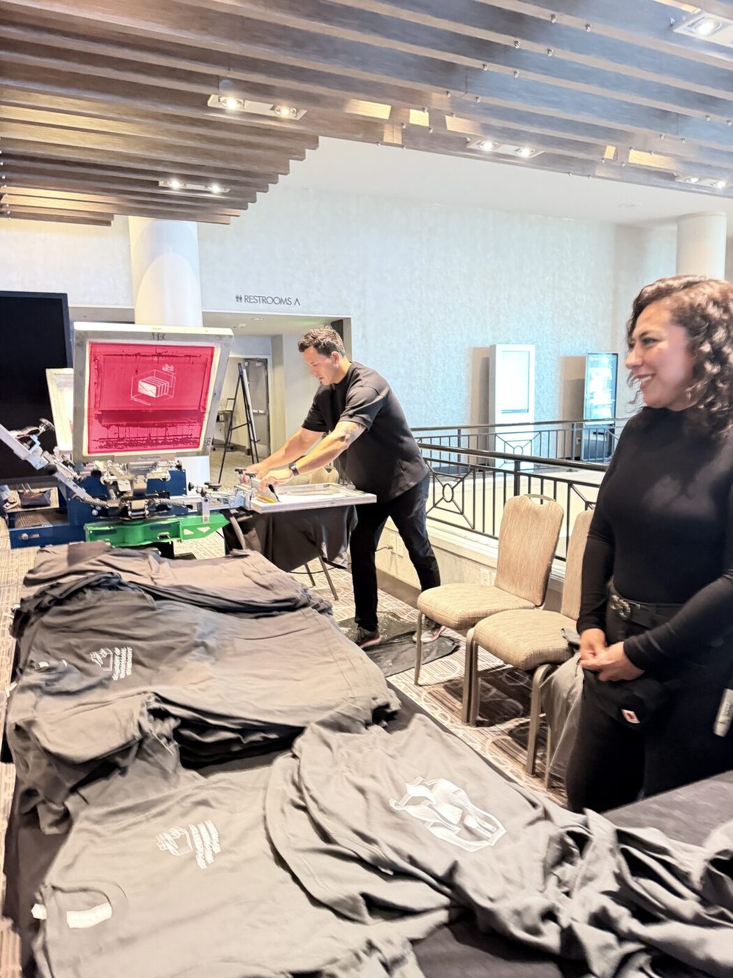 Operator pressing a custom transfer onto a garment at the printing bar